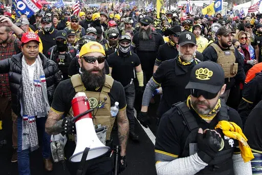Far-right Proud Boys member Jeremy Joseph Bertino, second from left, joins other supporters of President Donald Trump who are wearing attire associated with the Proud Boys as they attend a rally at Freedom Plaza, Dec. 12, 2020, in Washington. Bertino pleaded guilty on Thursday, Oct. 6, 2022, to plotting with other members of the Proud Boys to violently stop the transfer of presidential power after the 2020 election, making him the first member of the extremist group to plead guilty to a seditiou