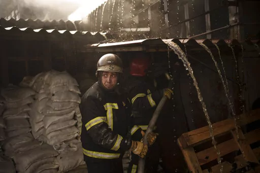 Firefighters battle a fire following a Russian attack in Kharkiv, Ukraine, Friday, March 25, 2022. (AP Photo/Felipe Dana)