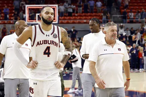 Auburn forward Johni Broome (4) and head coach Bruce Pearl walk off the court after losing to Alabama in overtime in an NCAA college basketball game, Saturday, March 8, 2025, in Auburn, Ala. (AP Photo/Butch Dill)