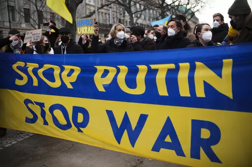 Demonstrators march along the street near the Russian embassy to protest against the escalation of the tension between Russia and Ukraine in Berlin, Germany, Tuesday, Feb. 22, 2022. Russian President Vladimir Putin has asked the country’s parliament for permission to use military force outside the country. That could presage a broader attack on Ukraine after the U.S. said an invasion was already underway there. (AP Photo/Markus Schreiber)