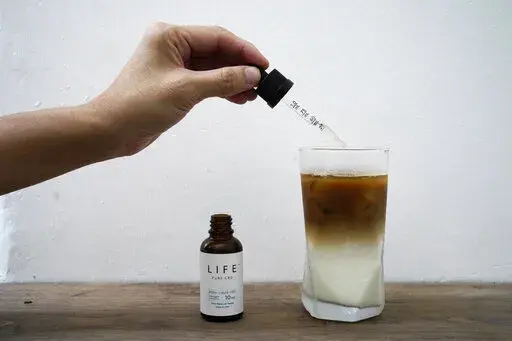 An employee adds drops of water-soluble CBD, or cannabidiol, an essential component of medical marijuana, into a coffee glass at the Found Cafe in Hong Kong on Sept. 13, 2020.Hong Kong will ban cannabidiol or CBD from the beginning of next month, authorities announced Friday, Jan. 27, 2023. (AP Photo/Vincent Yu, File)