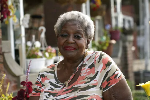 Pamela Jackson-Walters sits outside her home in Detroit, Wednesday, Sept. 21, 2022. Jackson-Walters uses her home internet connection to attend church services virtually and to pursue a graduate degree, but the service AT&T offers in her mostly Black neighborhood is much slower than in other parts of the city. She said she also experienced an internet outage for four weeks during the summer. (AP Photo/Paul Sancya)