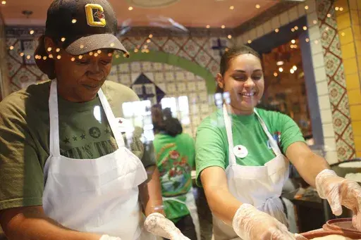 Latrice Walker and Christina Rivera make fresh tortillas on opening day at Chuy's in Jacksonville, N.C., May 13, 2014. On Wednesday, July 17, 2024, Darden Restaurants announced it's buying Chuy's restaurant chain. (AP Photo/The Daily News, Maria Sestito, File)