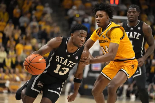 Mississippi State's Josh Hubbard (13) heads to the basket past Missouri's Anthony Robinson II (14) during the first half of an NCAA college basketball game Saturday, Feb. 10, 2024, in Columbia, Mo. (AP Photo/Jeff Roberson)
