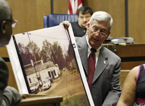 Prosecutor Doug Evans holds a photo during a trial for Curtis Flowers on June 14, 2010, in Greenwood, Miss. Evans is resigning Friday, June 30, 2023, after more than 30 years as district attorney and four years after the U.S. Supreme Court overturned Flowers' final conviction because it found that Evans had excluded Black people from jury service. Evans tried Flowers six times in the 1996 killings of four people. Flowers, who was released from prison in 2019, always maintained his own innocence.