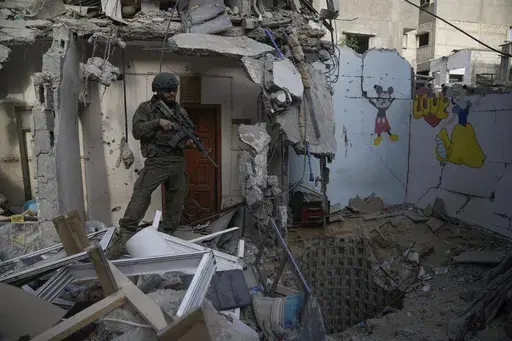 An Israeli soldier stands at the entrance of a tunnel where the military says six Israeli hostages were recently killed by Hamas militants in the southern Gaza Strip on Friday, Sept. 13, 2024. (AP Photo/Leo Correa)