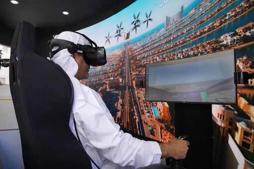 A man experiences a driving simulator of a flying taxi at the Dubai Roads and Transportation Authority's stand during the World Government SummitWLD in Dubai, United Arab Emirates, Monday, Feb 13, 2023. Dubai again is planning for the takeoff of flying taxis in this futuristic city-state on the Arabian Peninsula, offering its firmest details yet Monday for a pledged launch by 2026. (AP Photo/Kamran Jebreili)