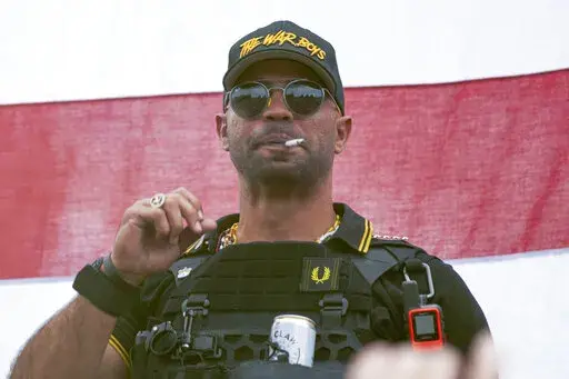 Proud Boys leader Henry "Enrique" Tarrio wears a hat that says The War Boys during a rally in Portland, Ore., on Sept. 26, 2020. The seditious conspiracy trial of Proud Boys leader Enrique Tarrio and four lieutenants is coming at a pivotal time for Justice Department's investigation and prosecution of the Jan. 6, 2021 insurrection. (AP Photo/Allison Dinner, File)
