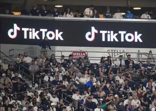 Fans sit under a TikTok ad at a baseball game at Yankee Stadium, April 14, 2023, in New York. A bill that could lead to the popular video-sharing app TikTok being unavailable in the United States is quickly gaining traction in the House. Lawmakers advanced legislation against TikTok Thursday as they voiced concerns about the potential for the platform to surveil and manipulate Americans. (AP Photo/Frank Franklin II, File)