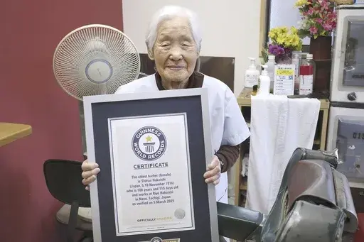 Shitsui Hakoishi, 108, poses for a photo with a Guinness World Records certificate recognizing her as the world's oldest female barber, at her shop in Nakagawa in Tochigi Prefecture, eastern Japan, on Wednesday March 5, 2025. (Kyodo Photo via AP)