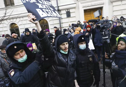 Police officers detain a demonstrator as people gather in front of the Supreme Court of the Russian Federation, in Moscow, Russia, Tuesday, Dec. 28, 2021. Russia’s Supreme Court has ruled that one of the country’s oldest and most prominent human rights organizations should be shut down. The move is the latest step in a months-long crackdown on dissent. The Prosecutor General’s Office last month petitioned the Supreme Court to revoke the legal status of Memorial — an international human r