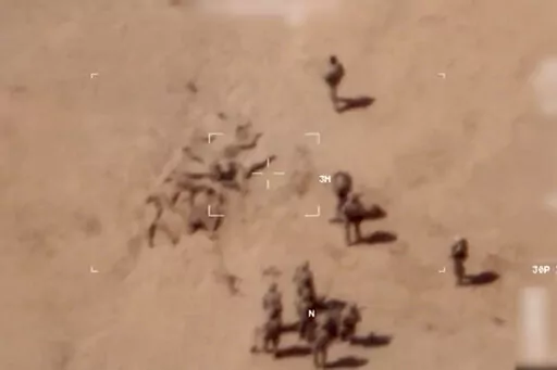 This image taken from a video shows soldiers burying bodies near an army base in northern Mali. The French military says it has videos of Russian mercenaries burying bodies near an army base in northern Mali which it says is part of a smear campaign against the French who handed control of the base to Malian forces earlier this week. Aerial surveillance taken by the French military early Thursday and provided to The Associated Press show what appear to be 10 Caucasian soldiers covering approxima