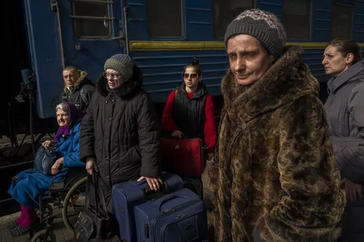 Ukrainians escaping from the besieged city of Mariupol along with other passengers from Zaporizhzhia arrive at Lviv, western Ukraine, on Sunday, March 20, 2022. (AP Photo/Bernat Armangue)