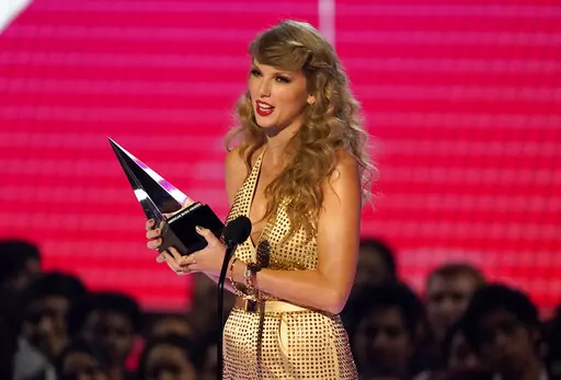 Taylor Swift accepts the award for favorite pop album for "Red (Taylor's Version)" at the American Music Awards on Nov. 20, 2022, at the Microsoft Theater in Los Angeles. Swift’s signed acoustic guitar, Eminem’s signed tennis shoes and an ensemble worn by a BTS member are among the items up for bid during a Grammy-week auction on Feb. 5, 2023, Julien’s Auctions said Tuesday, Jan. 17. (AP Photo/Chris Pizzello, File)