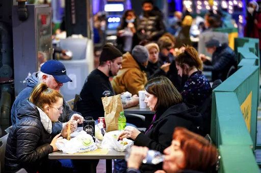 Customers eat at the Reading Terminal Market in Philadelphia, Wednesday, Feb. 16, 2022.  Philadelphia city officials lifted the city's vaccine mandate for indoor dining and other establishments that serve food and drinks, but an indoor mask mandate remains in place. Philadelphia Public Health officials announced that the vaccine mandate was lifted immediately Wednesday. (AP Photo/Matt Rourke)