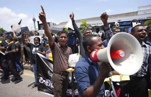 Sri Lankans representing various government establishments shout slogans against the government during a protest in Colombo, Sri Lanka, Wednesday, April 20, 2022. Thousands of people across Sri Lanka are taking to the streets, a day after police opened fire at demonstrators, killing one person and injuring 13 others, reigniting widespread protests amid the country's worst economic crisis in decades. Placards reads demands against privatisation and increasing  costs of living. (AP Photo/Eranga Ja