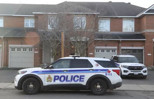Police cars are parked at the scene where six people were found dead in the Barrhaven suburb of Ottawa on Thursday, March 7, 2024. (Patrick Doyle /The Canadian Press via AP)