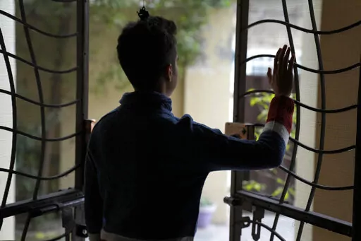 Pakistani trans man Aman, who asked not be identifiable in the photo, looks out at his home after an interview with The Associated Press, in Lahore, Pakistan, Friday, Dec. 2, 2022. Trans people are considered outcasts by many in Pakistan, despite some progress with a law protecting their rights and court rulings that allow them to choose a gender that is neither male nor female. But the struggle for acceptance and inclusion is harder for Pakistan's trans men, who say they lack the same level of 