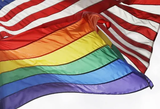 The LGBTQ+ pride flag flies beneath the American flag at the Stonewall National Monument, Oct. 11, 2017, in New York. Veterans Affairs Secretary Denis McDonough has authorized flying of the LGBTQ+ pride flag at all VA facilities throughout Pride Month, VA Press Secretary Terrence Hayes said in a statement on Tuesday, June 6, 2023. (AP Photo/Mark Lennihan, File)