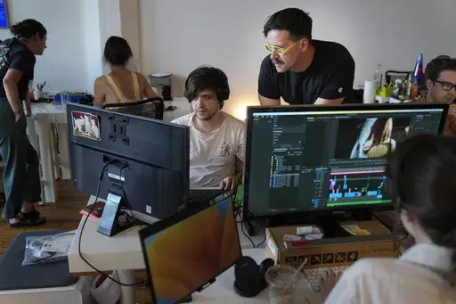Chris Langer, top right, co-founder of CMYK, a digital design agency, speaks with an staff member at their office in New York, Tuesday, June 25, 2024. Last year, Langer started hearing chatter about the four-day work week, so he decided to try it out during the summer. (AP Photo/Seth Wenig)