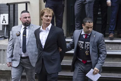 Daniel Penny, center, is walked by New York Police Department detectives out of the 5th Precinct on May. 12, 2023, in New York. Republican presidential hopefuls have rushed to support Penny, a white U.S. Marine veteran who was caught on video pinning an agitated Black subway passenger to the floor in a fatal chokehold.(AP Photo/Jeenah Moon, File)