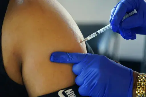A Jackson, Miss., resident receives a Pfizer booster shot from a nurse at a vaccination site Feb. 8, 2022. On Friday, Jan. 6, 2023, The Associated Press reported on stories circulating online incorrectly claiming two researchers found that more than 1,500 athletes have suffered cardiac arrest since COVID-19 vaccinations began. (AP Photo/Rogelio V. Solis, File)