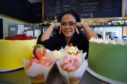 Shirley Hughes, owner of Sweet Cheats bakery, poses for a photo, Friday, April 15, 2022, in Atlanta.  Some small businesses are still struggling to hire qualified workers, even as the broader picture in the U.S. job market looks much brighter.  (AP Photo/Mike Stewart)