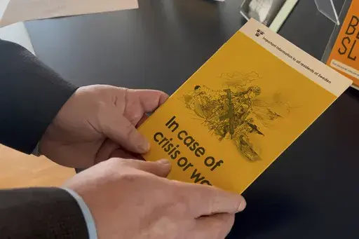 Jan-Olof Olsson, Critical Infrastructure Protection (CIP) expert at the Swedish Civil Contingencies Agency (MSB) holds a yellow crisis preparedness brochure titled "In case of crisis or war", which was distributed to all Swedish households, Thursday, Dec. 26, 2024, in Karlstad, Sweden. (AP Photo/Mimmi Montgomery)