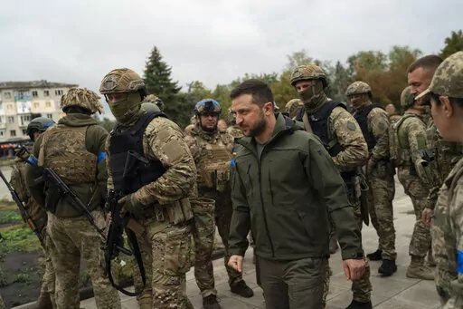 Surrounded by soldiers the Ukrainian President Volodymyr Zelenskyy attends a national flag-raising ceremony in the freed Izium, Ukraine, Wednesday, Sept. 14, 2022. A tart retort by Zelenskyy to a U.S. offer of help and a call by former U.S. President Donald Trump for the "termination" of parts of the Constitution top a Yale Law School librarian's list of the most notable quotations of 2022. (AP Photo/Leo Correa, File)
