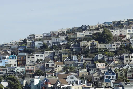 A plane flies over homes and residential buildings in San Francisco, Wednesday, March 4, 2020. California lawmakers have reached a deal on a pair of housing production bills. The bills would open up much of the state's commercial land for residential development. California has a housing shortage. (AP Photo/Jeff Chiu, File )