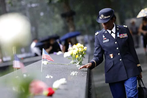 A retired colonel from the U. S. Army Nurse Corps walks beside the reflecting pool at the commemoration ceremony on the 21st anniversary of the September 11, 2001 terror attacks on Sunday, Sept. 11, 2022 in New York. (AP Photo/Stefan Jeremiah)