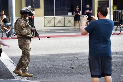 A pedestrian photographs a U.S. National Guardsman as he patrols Hollywood Blvd., May 31, 2020, in Los Angeles. The Republican leaders of the Arizona Legislature will not try to defend a new law that has been blocked by a federal judge that limits up-close filming of police, a decision that essentially ends the fight over the contentious proposal. (AP Photo/Chris Pizzello, File)