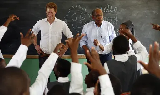 Britain's Prince Harry, left, accompanied by Prince Seeiso of Lesetho, meets pupils in a class during his visit to the Kananelo Centre for the Deaf outside Maseru, Lesotho, Wednesday, Feb. 27, 2013. (AP Photo/Themba Hadebe, File)