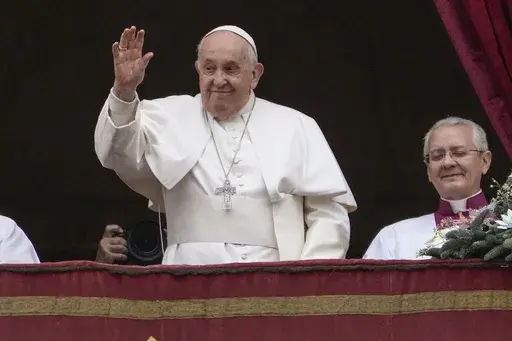 Pope Francis waves before delivering the Urbi et Orbi (Latin for 'to the city and to the world' ) Christmas' day blessing from the main balcony of St. Peter's Basilica at the Vatican, Monday Dec. 25, 2023. (AP Photo/Gregorio Borgia)