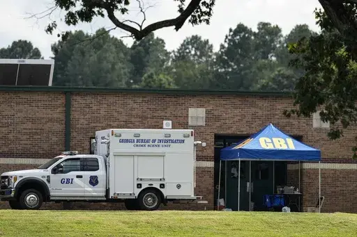 Georgia Bureau of Investigation staff move through an entrance to Apalachee High School after Wednesday's shooting, Thursday, Sept. 5, 2024, in Winder, Ga. (AP Photo/Mike Stewart)