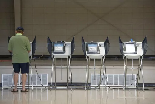 A voter uses an electronic voting machine to cast a ballot in the Mississippi primary election at a polling location in Jackson County, Miss., on June 7, 2022. Mississippi voters will be able to use their smartphones as voter identification in the November election, marking the first real test of a new statewide program that integrates technology into the voting process. (Hannah Ruhoff/The Sun Herald via AP, File)