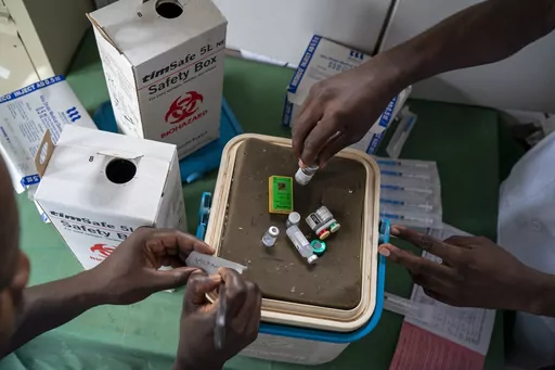 Health officials prepare to vaccinate residents of the Malawi village of Migowi, Tuesday, Dec. 10, 2019 where young children become test subjects for the world's first vaccine against malaria. Cameroon is beginning the world's first routine immunization program against malaria for children, a move that experts hope will mark the start of a campaign across Africa to dampen the impact of the parasitic disease. (AP Photo/Jerome Delay)