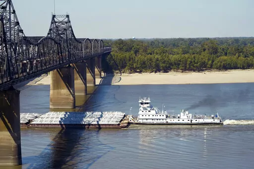 Low-water restrictions on the barge loads make for cautious navigation through the Mississippi River as evidenced by this tow passing under a Mississippi River bridge in Vicksburg, Tuesday, Oct. 11, 2022. The unusually low water level in the lower Mississippi River has caused some barges to get stuck in the muddy river bottom, resulting in delays. (AP Photo/Rogelio V. Solis)
