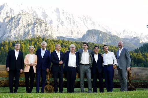 Members of the G7 from left, Prime Minister of Italy Mario Draghi, European Commission President Ursula von der Leyen, President Joe Biden, German Chancellor Olaf Scholz, British Prime Minister Boris Johnson, Canadian Prime Minister Justin Trudeau, Prime Minister of Japan Fumio Kishida, French President Emmanuel Macron and European Council President Charles Michel stand for a photo at Schloss Elmau following their dinner at G7 Summit in Elmau, Germany, Sunday, June 26, 2022. The bench behind the