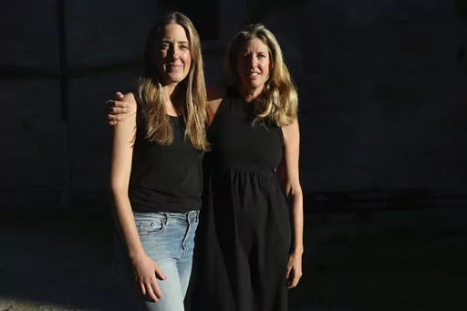 Hillary Jackson, from New York, right, and Kristy Benner, from Los Angeles, pose outside the Saint-Andre hospital in Bordeaux, southwestern France, Thursday, Sept.14, 2023. Kristy Benner's partner Matt Jackson was riding an electric bike through Bordeaux wine country on vacation when he started feeling strange. Nine days later, he's on a breathing machine in a French ICU, unable to open his eyes, communicating only via notes on a whiteboard and infected with botulism. A 32-year-old woman died in
