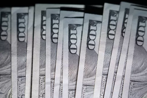 U.S. $100 bills are seen, Thursday, July 14, 2022, in Marple Township, Pa. In many ways, retirement planning for someone in the LGBTQ+ community follows the basic tenets of anyone’s retirement planning: save more, spend less, invest for the long term. But there are some unique challenges. (AP Photo/Matt Slocum, File)
