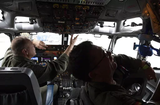 Pilots work in the cockpit of an AWACS plane at Melsbroek military airport in Melsbroek, Belgium, Wednesday, Nov. 27, 2019. As Russia’s military buildup near Ukraine accelerated early this year, military planners at NATO began preparing to dispatch scores of fighter jets and surveillance aircraft into the skies near Russia and Ukraine. It was a warning to Moscow not to make the mistake of targeting any member country. (AP Photo/Virginia Mayo, File)