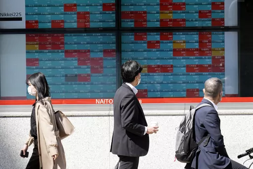 Pedestrians pass by an electronic stock board showing Japan's Nikkei 225 index at a securities firm, April 27, 2023, in Tokyo. Asian shares declined in muted trading Wednesday, May 10, 2023 as investors awaited an upcoming report on U.S. inflation, an important indicator for where interest rates and global growth might go in the coming months. (AP Photo/Eugene Hoshiko, File)