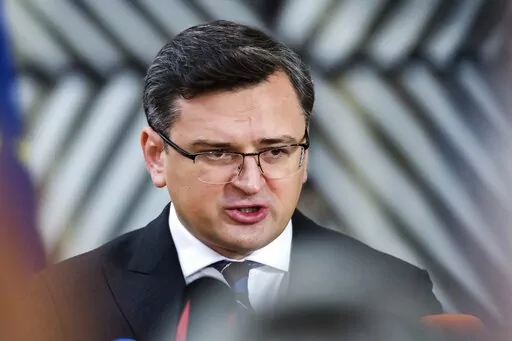 FILE Ukraine's Foreign Minister Dmytro Kuleba speaks with journalists as he arrives for a round table meeting of the Eastern Partnership at the European Council building in Brussels, Monday, Nov. 15, 2021. Ukraine said Sunday, Jan. 16, 2022 that Russia was behind a cyberattack that defaced its government websites and alleged that Russia is engaged in an increasing "hybrid war" against its neighbor. (AP Photo/Geert Vanden Wijngaert, File)