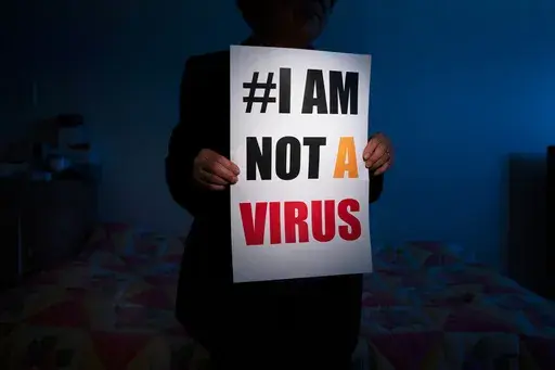 Jen Ho Lee, a 76-year-old South Korean immigrant, poses in her apartment with a sign from a recent rally against anti-Asian hate crimes she attended Wednesday, March 31, 2021, in Los Angeles. (AP Photo/Jae C. Hong, File)