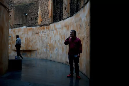 Jonatan, 26, smokes a cigarette in a designated area of the Bepo Ghezzi Social Inclusion Center, in the Parque Patricios neighborhood of Buenos Aires, Argentina, Thursday, Sept. 21, 2023. Jonatan said he would be sleeping on the streets if it weren't for the city-run shelter where in addition to a bed, hot showers and four meals a day, residents receive psychological support and training to reenter the workforce. (AP Photo/Natacha Pisarenko)
