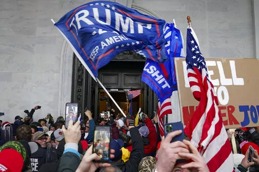 In this Jan. 6, 2021, file photo rioters break into the Capitol in Washington. U.S. District Judge Emmet Sullivan refused to accept a guilty plea by Anthime Gionet after he professed his innocence at the start of what was scheduled to be a plea agreement hearing. Instead, the judge set a March 2023 trial date for Gionet, who is charged with a misdemeanor count of parading, demonstrating or picketing inside a Capitol building.  (AP Photo/John Minchillo, File)