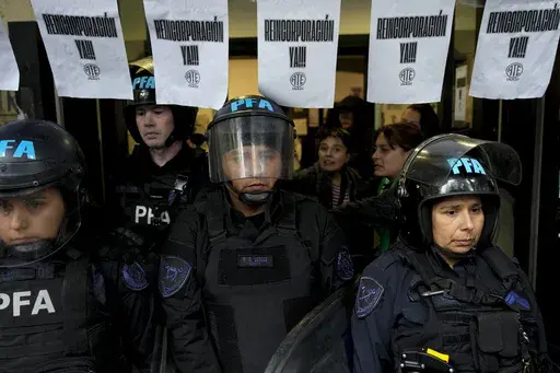 Police stand guard outside the National Institute against Discrimination, Xenophobia, and Racism, to prevent workers from entering after they were laid off in Buenos Aires, Argentina, Wednesday, April 3, 2024. During his four months in office, President Javier Mile has closed the Ministry of Women, Gender and Diversity, banned the government’s use of gender-inclusive language and shuttered the National Institute against Discrimination, Xenophobia and Racism. (AP Photo/Natacha Pisarenko)