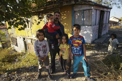 Nidal Jumaa, a Syrian from Aleppo, poses with his children outside their house in a low-income neighbourhood in Ankara, Wednesday, Nov. 9, 2022. Syrians fleeing their country's civil war were once welcomed in Turkey out of compassion, making the country home to the world’s largest refugee community. But as their numbers grew — and as Turkey began to grapple with a battered economy, including skyrocketing food and housing prices — so did calls for their return, with the repatriation of Syri