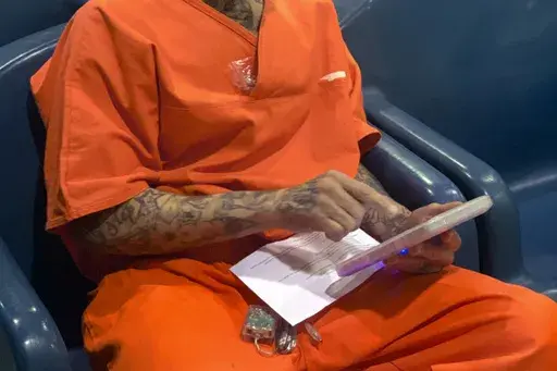 In this image provided by the North Fork Correctional Center in Sayre, Okla., on Tuesday, June 9, 2021, an inmate Byron Robinson works on a tablet, which are being provided for free to Oklahoma inmates as part of a new program by the Department of Corrections. (Lance West/Oklahoma Department of Corrections via AP)
